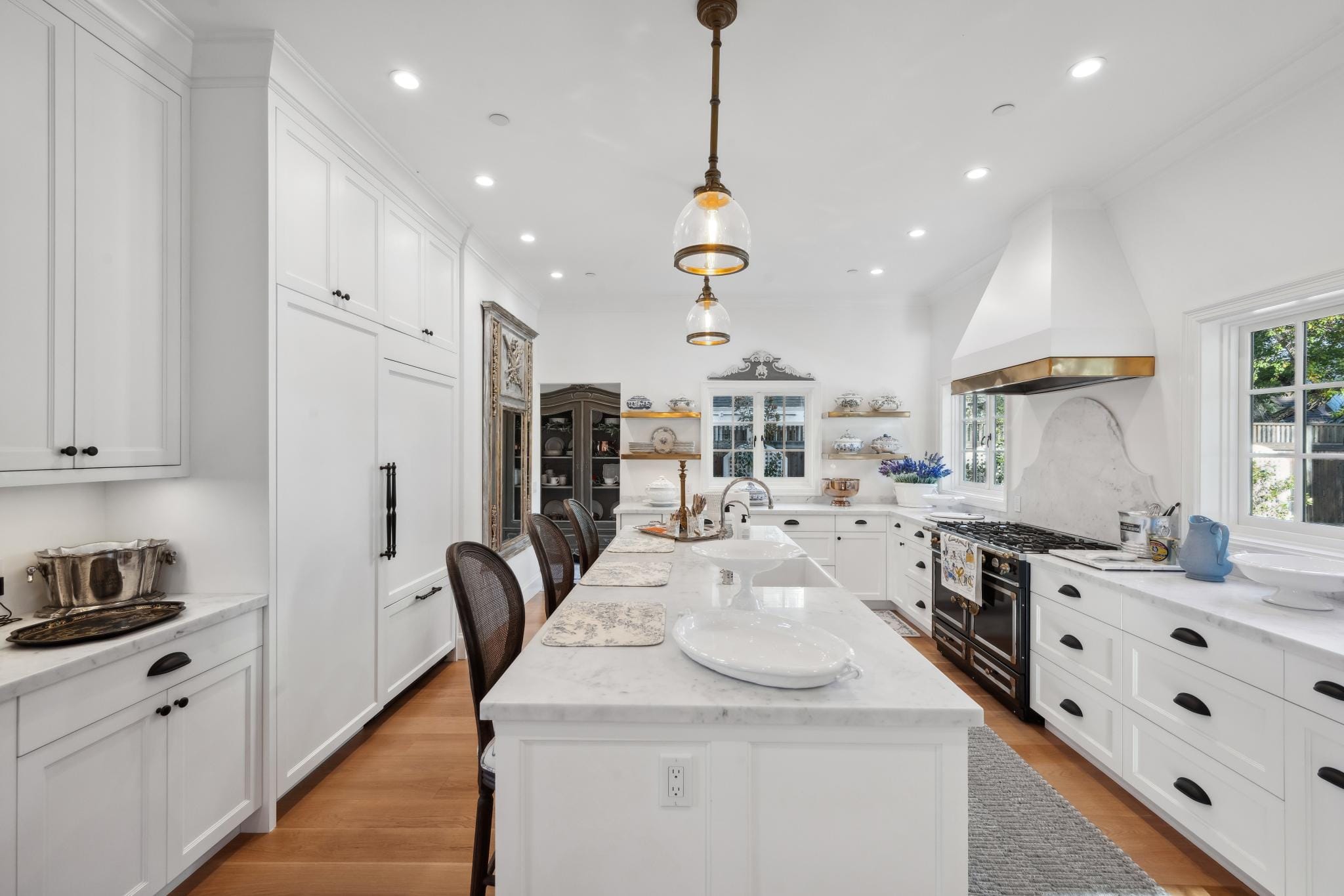 Long view of white French country kitchen with black La Cornue range, marble countertops, and black cup-pull hardware at 853 D Street, Petaluma
