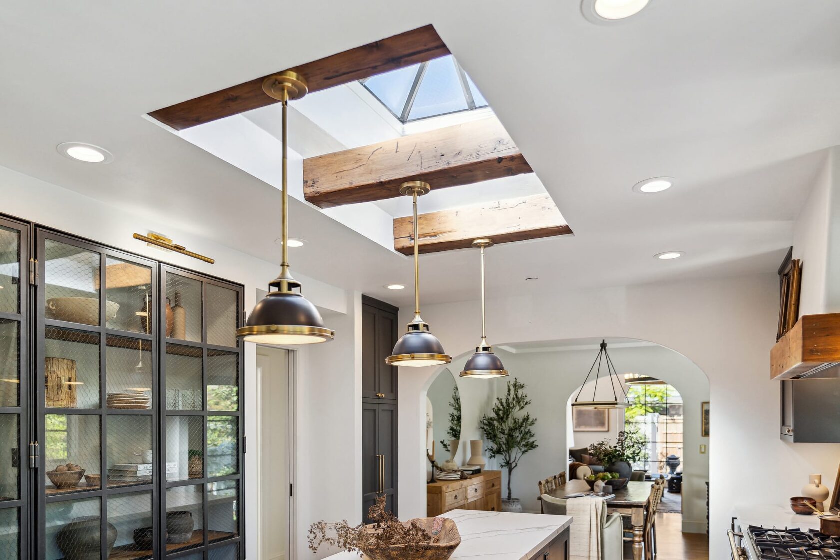 Dual skylights and exposed wood ceiling beams flooding a dark farmhouse kitchen with natural light at 137 Oak Knoll Avenue