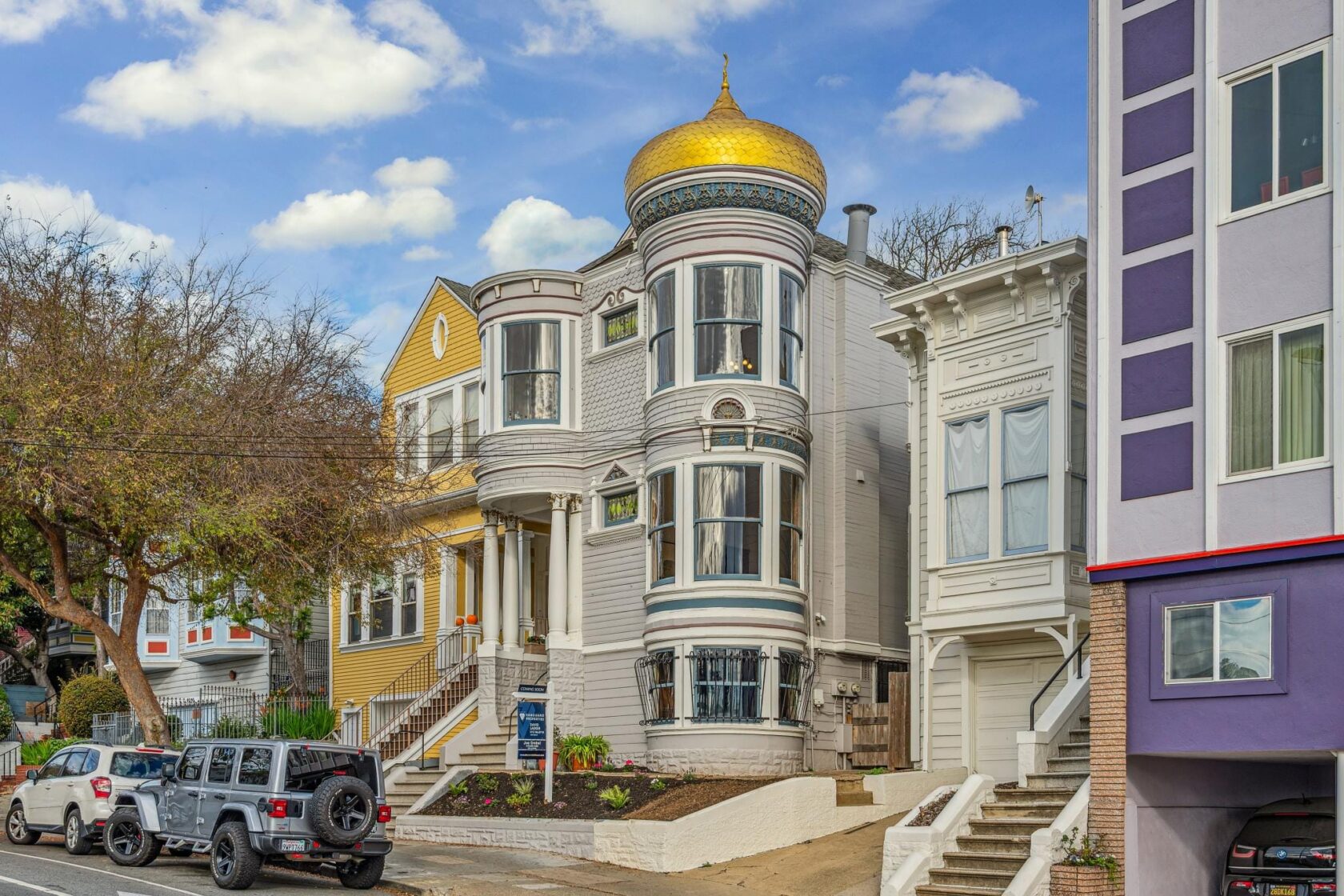 Street-level view of the McCormick House, a Victorian-era multi-unit building featuring a distinctive gold onion dome, rounded bay windows, and ornate white trim, flanked by neighboring homes in the Castro.