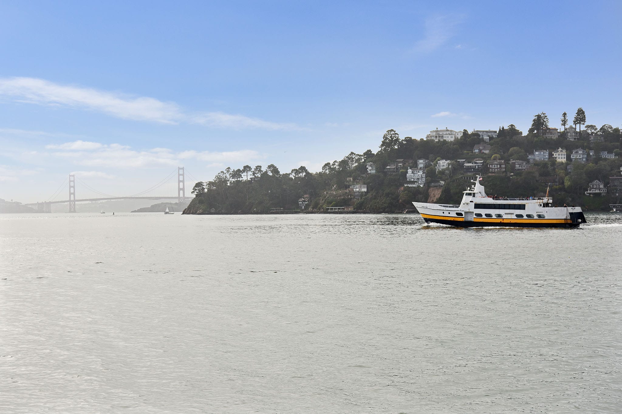 Golden Gate Ferry crossing San Francisco Bay with Golden Gate Bridge and Belvedere hillside visible in the background