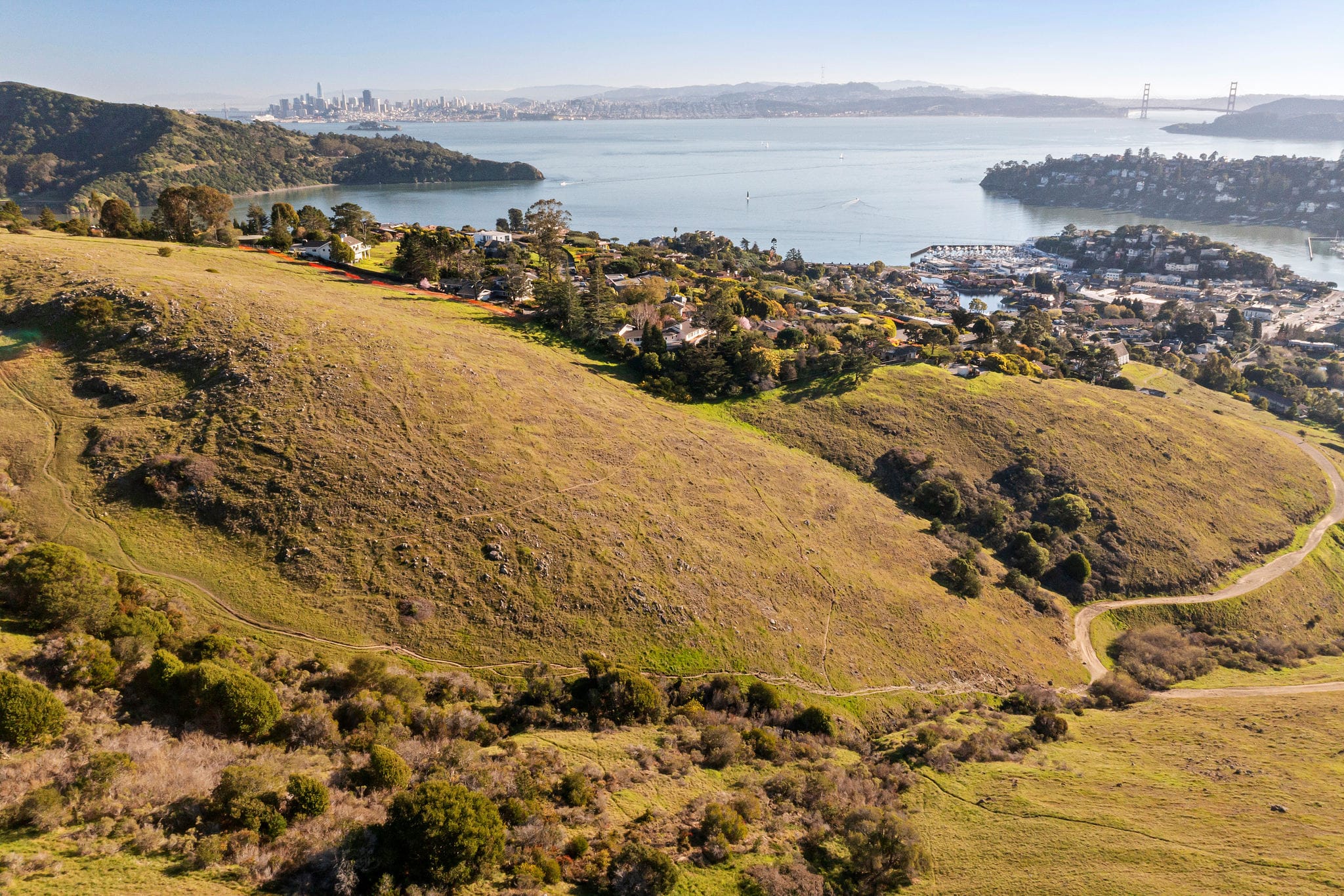 Aerial drone view of Belvedere Island with San Francisco skyline and Golden Gate Bridge visible across the bay