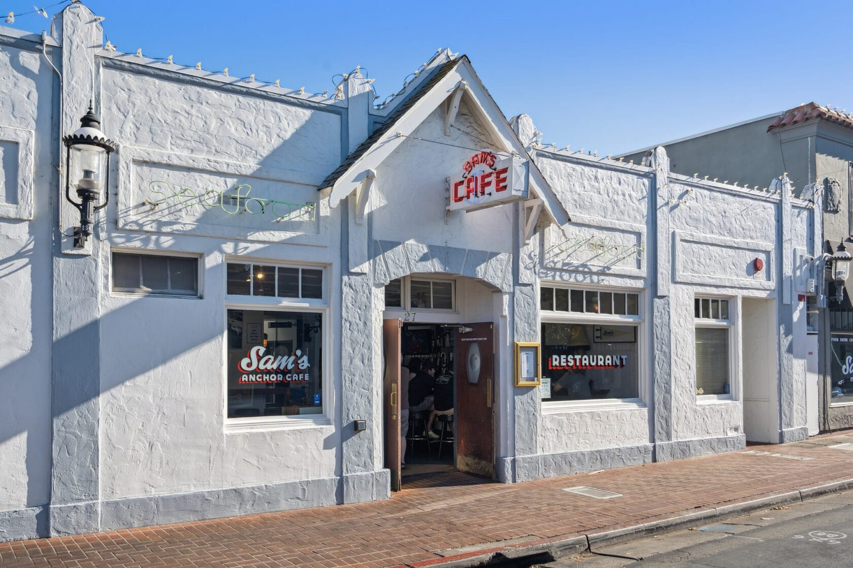 Exterior of Sam's Anchor Cafe on Main Street in Tiburon CA, a white stucco building with vintage neon signage