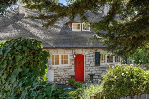 The front of a Carmel-by-the-Sea home peeks through shrubbery